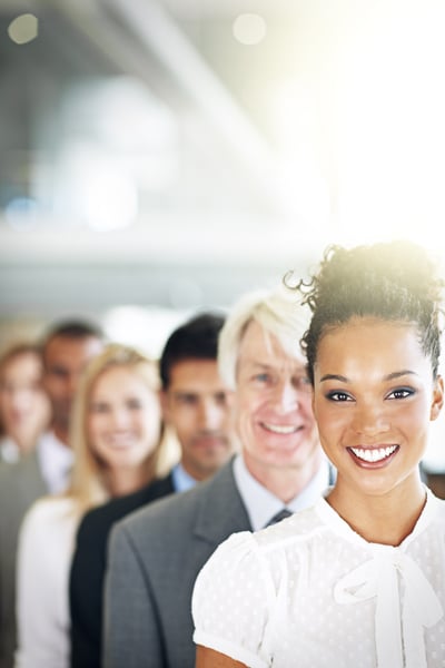 Professional business people lined up and smiling