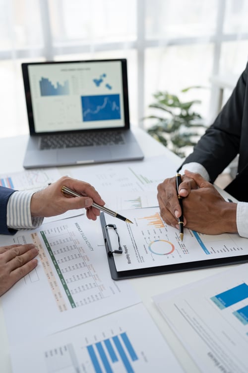 business people reviewing performance graphs business people reviewing performance graphs